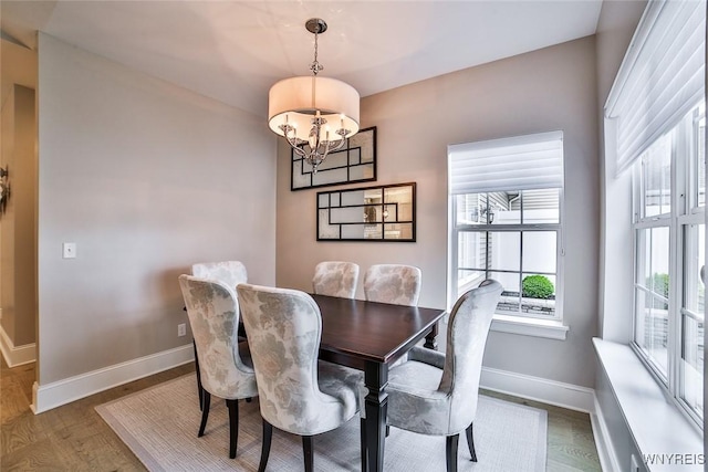 5692 Ferncrest Ct Unit B, Clarence, NY 14032 - dining area featuring a chandelier, baseboards, and wood finished floors