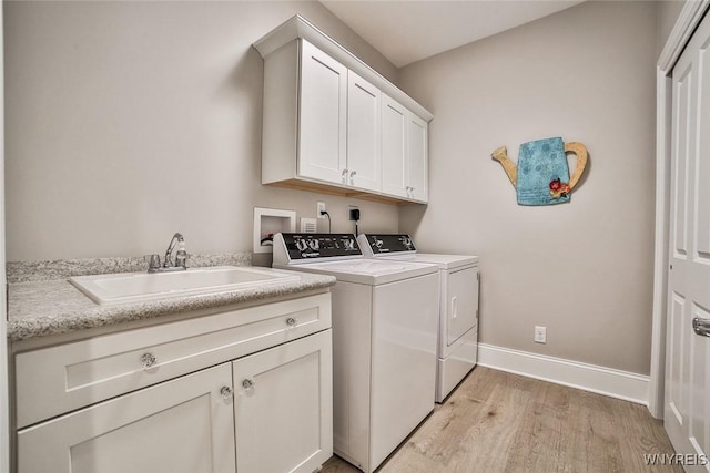 5692 Ferncrest Ct Unit B, Clarence, NY 14032 - washroom featuring washing machine and clothes dryer, light wood-style flooring, cabinet space, and baseboards
