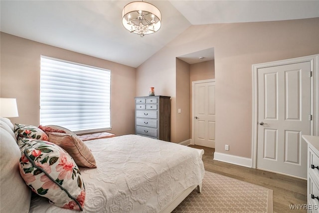 5692 Ferncrest Ct Unit B, Clarence, NY 14032 - bedroom featuring wood finished floors, lofted ceiling, a chandelier, and baseboards