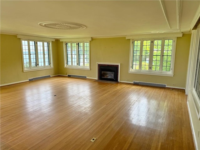 700 Rock Beach Rd, Irondequoit, NY 14617 - unfurnished living room featuring a fireplace, wood finished floors, crown molding, a baseboard radiator, and baseboards