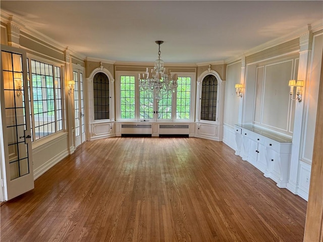 700 Rock Beach Rd, Irondequoit, NY 14617 - unfurnished dining area featuring a chandelier, wood finished floors, crown molding, plenty of natural light, and a decorative wall