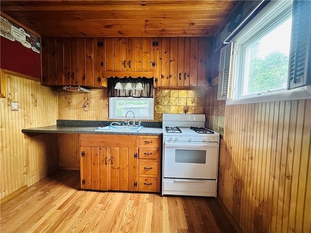 218 Grant St, Elmira-City, NY 14901 - kitchen with white range with gas cooktop, a sink, wooden ceiling, brown cabinets, and light wood-style floors
