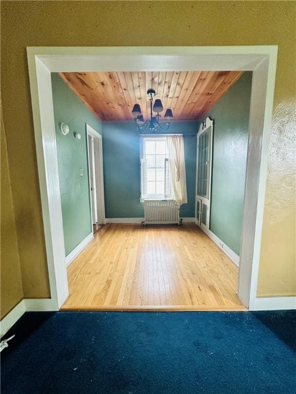 218 Grant St, Elmira-City, NY 14901 - spare room featuring radiator heating unit, hardwood / wood-style floors, a chandelier, wooden ceiling, and baseboards