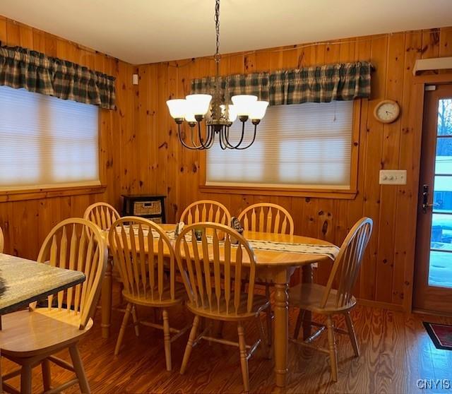 103 Onondaga Rd, Webb, NY 13420 - dining area with wood finished floors, a chandelier, and wood walls