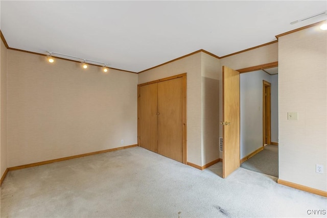 10 Garfield St Unit 10, Cortland, NY 13045 - unfurnished bedroom featuring track lighting, light carpet, ornamental molding, baseboards, and a closet