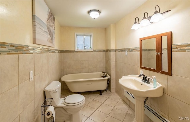 8929 State Route 12e, Lyme, NY 13622 - bathroom with tile walls, a freestanding bath, tile patterned floors, a baseboard heating unit, and toilet