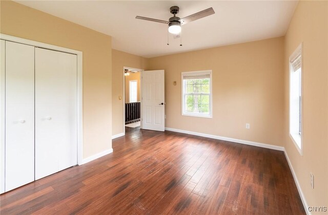 8929 State Route 12e, Lyme, NY 13622 - unfurnished bedroom featuring dark wood-style floors, baseboards, a closet, and ceiling fan