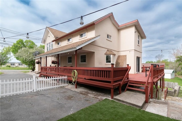 8929 State Route 12e, Lyme, NY 13622 - rear view of property with stucco siding, a wooden deck, and roof with shingles