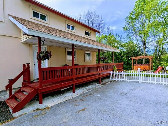 8929 State Route 12e, Lyme, NY 13622 - view of front facade featuring stucco siding, a shingled roof, and a porch