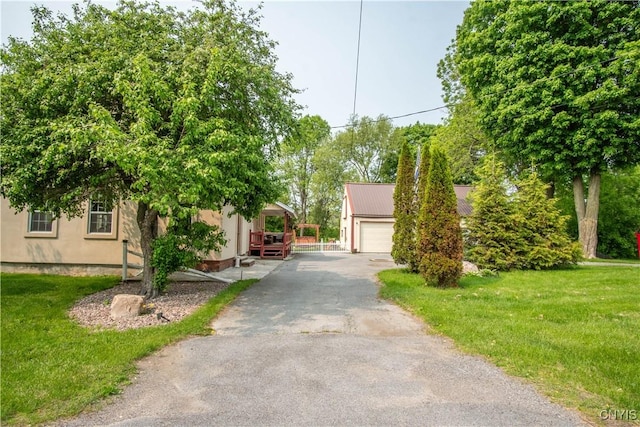 8929 State Route 12e, Lyme, NY 13622 - obstructed view of property featuring stucco siding, a detached garage, a front lawn, and an outbuilding