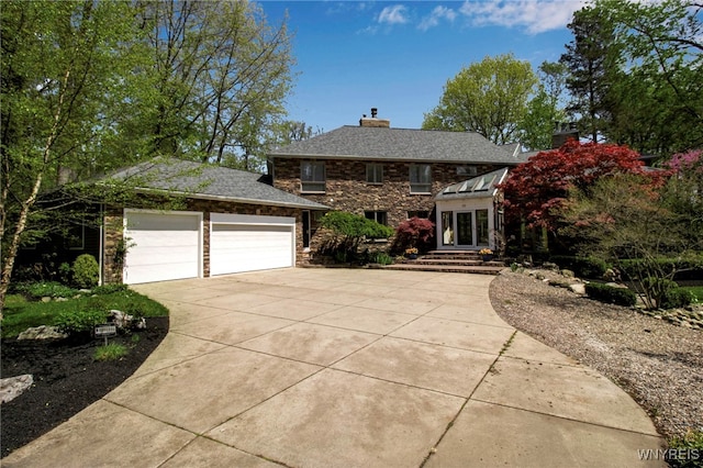 52 Hidden Pines Ct, Amherst, NY 14051 - view of front of house featuring concrete driveway, a chimney, stone siding, and a garage