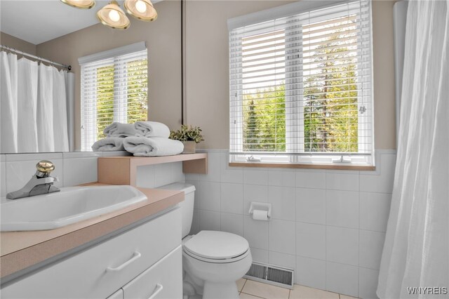52 Hidden Pines Ct, Amherst, NY 14051 - full bathroom featuring vanity, toilet, plenty of natural light, wainscoting, and tile walls