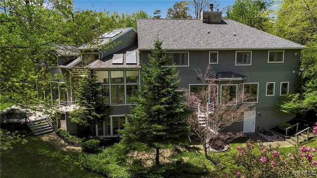 52 Hidden Pines Ct, Amherst, NY 14051 - back of property with stairway, a chimney, and a sunroom
