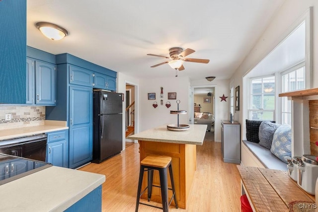 106 Hillside Way, Camillus, NY 13031 - kitchen featuring freestanding refrigerator, blue cabinets, a kitchen bar, and light wood finished floors