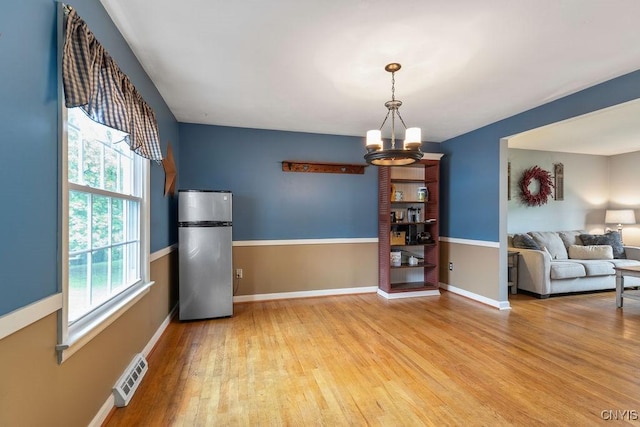 106 Hillside Way, Camillus, NY 13031 - dining area featuring a chandelier, plenty of natural light, light wood-style flooring, and baseboards