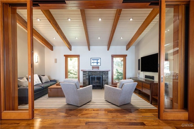9182 S Rhodes Rd, Lodi, NY 14860 - living room with wood-type flooring, a stone fireplace, beamed ceiling, and recessed lighting