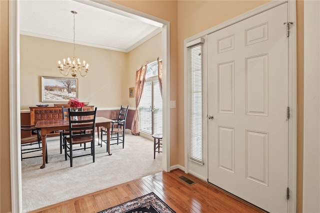 4166 Angela Way, Gorham, NY 14424 - entrance foyer with light wood finished floors, a chandelier, crown molding, and baseboards
