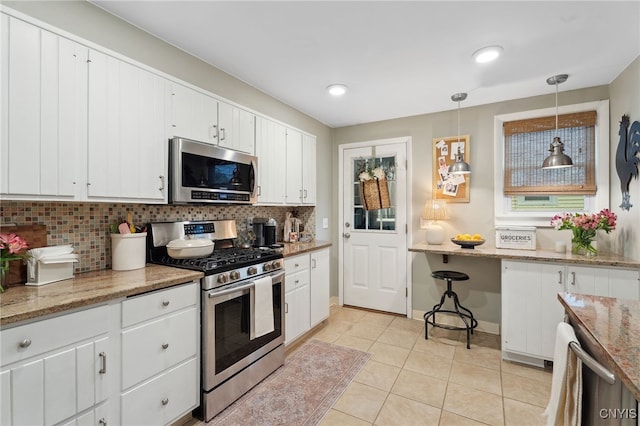 34-36 Hamilton Ave, Auburn, NY 13021 - kitchen featuring appliances with stainless steel finishes, backsplash, light tile patterned floors, white cabinets, and recessed lighting