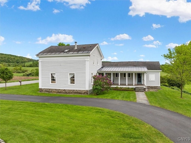 537 Earlville Rd, Hamilton, NY 13332 - view of front of house with a standing seam roof, covered porch, metal roof, and a front lawn