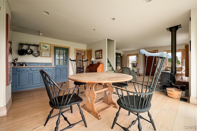 537 Earlville Rd, Hamilton, NY 13332 - dining room featuring a wood stove, light wood-type flooring, stairway, and recessed lighting