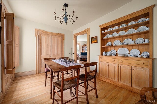 537 Earlville Rd, Hamilton, NY 13332 - dining room featuring light wood finished floors, a chandelier, and baseboards