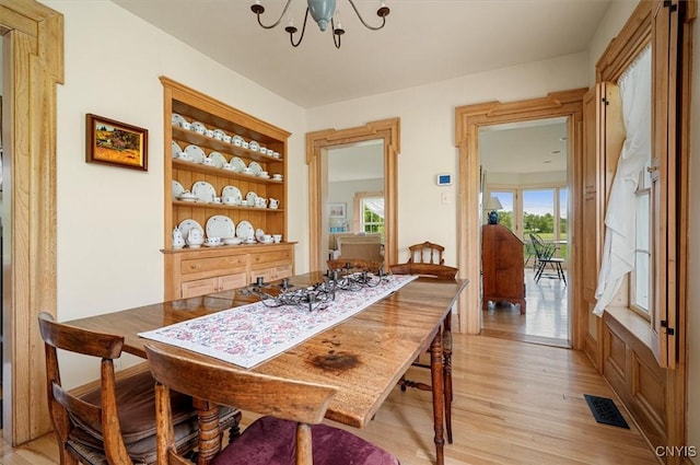 537 Earlville Rd, Hamilton, NY 13332 - dining room with a chandelier, light wood-style flooring, and built in shelves