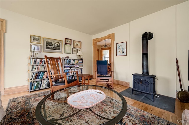 537 Earlville Rd, Hamilton, NY 13332 - sitting room with wood finished floors, baseboards, and a wood stove