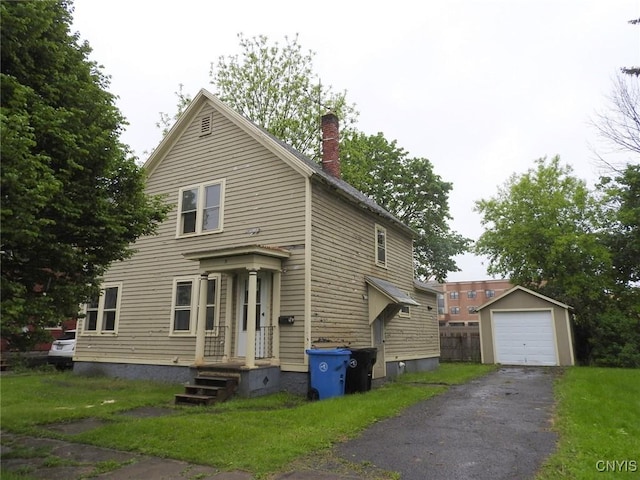 5 Evergreen St, Cortland, NY 13045 - traditional-style house featuring asphalt driveway, an outdoor structure, a garage, and a chimney