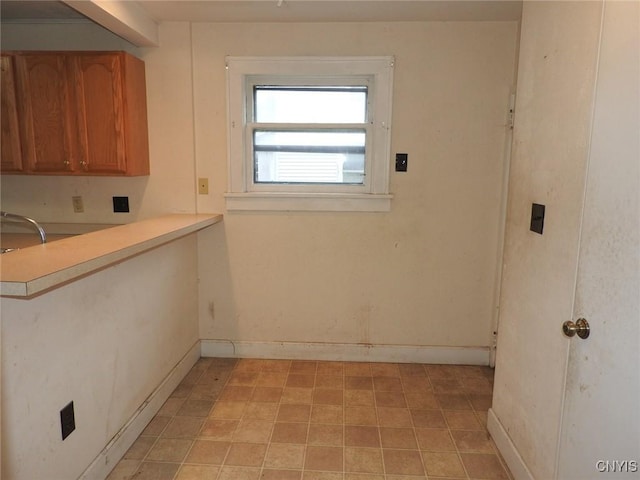 5 Evergreen St, Cortland, NY 13045 - kitchen featuring baseboards, light countertops, a sink, and brown cabinets