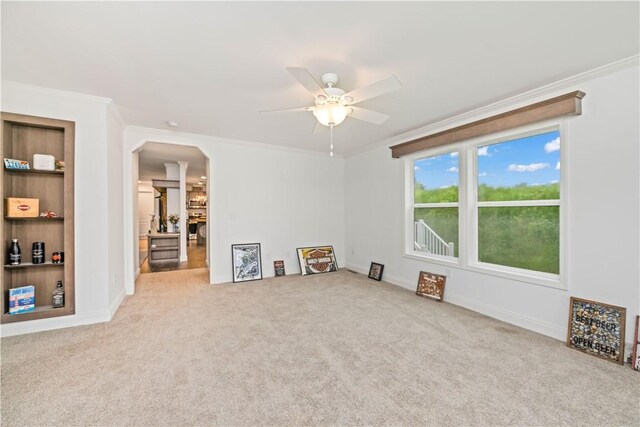 3854 Tari Ln, Murray, NY 14470 - unfurnished living room with ornamental molding, a ceiling fan, carpet flooring, arched walkways, and baseboards