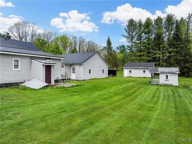 9748-9736 Podunk Rd, Lee, NY 13363 - rear view of property with a lawn, an outbuilding, metal roof, and entry steps