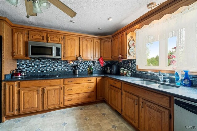 9748-9736 Podunk Rd, Lee, NY 13363 - kitchen with appliances with stainless steel finishes, brown cabinets, a sink, ceiling fan, and a textured ceiling