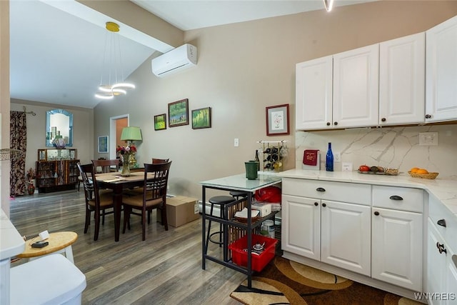 454 Kenwood Dr, Lewiston, NY 14092 - kitchen with a wall mounted air conditioner, light wood finished floors, light countertops, tasteful backsplash, and white cabinets