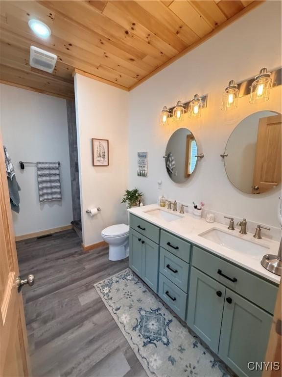 26633 Kring Point Rd, Alexandria, NY 13679 - bathroom featuring wood ceiling, double vanity, toilet, wood finished floors, and baseboards
