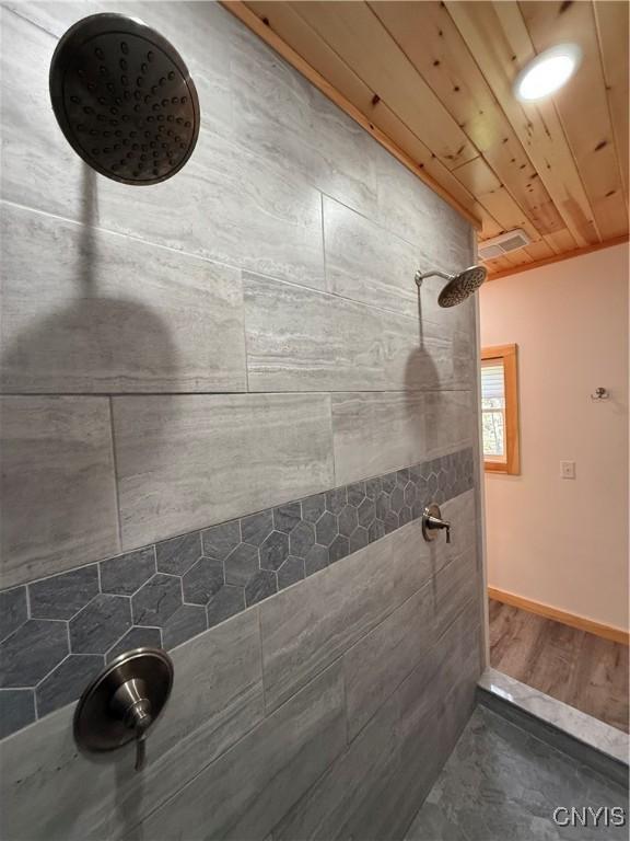 26633 Kring Point Rd, Alexandria, NY 13679 - full bathroom featuring a tile shower, wood ceiling, and baseboards