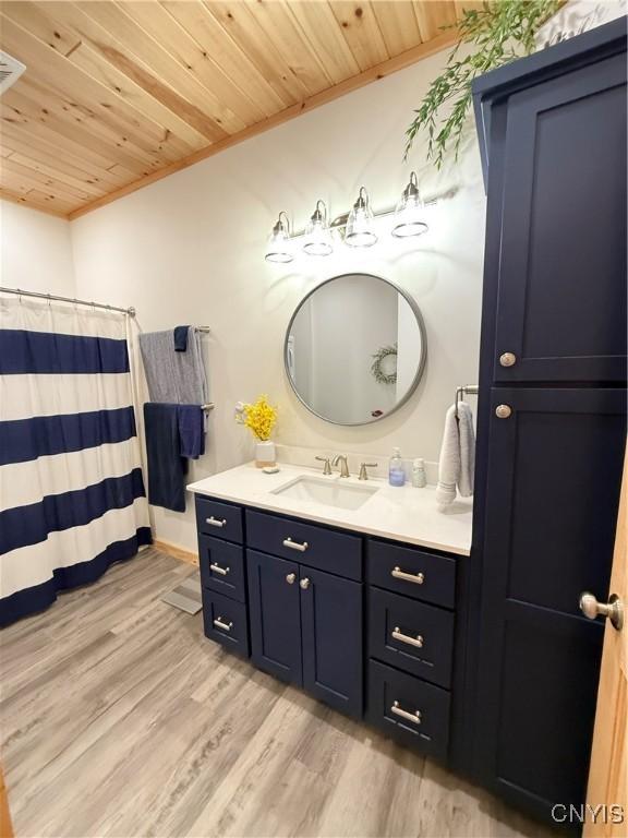 26633 Kring Point Rd, Alexandria, NY 13679 - bathroom with wooden ceiling, vanity, wood finished floors, crown molding, and a shower with shower curtain