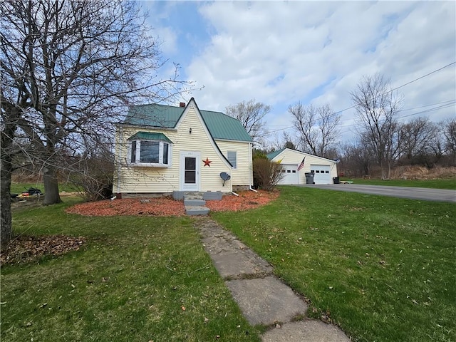 921 County Route 82, Troupsburg, NY 14885 - view of front of house with a front yard, a garage, metal roof, a chimney, and an outbuilding