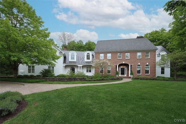 7106 Braxton Cir, Dewitt, NY 13066 - view of front of home featuring a front lawn, a chimney, and brick siding