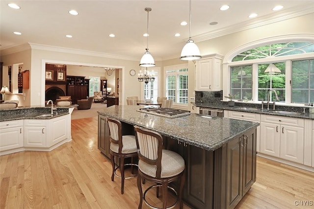 7106 Braxton Cir, Dewitt, NY 13066 - kitchen featuring appliances with stainless steel finishes, light wood-style floors, white cabinets, a sink, and a center island