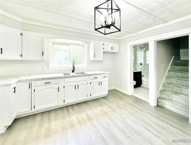 169 Davidson Ave, Buffalo, NY 14215 - kitchen with a sink, white cabinetry, light wood-type flooring, and light stone countertops