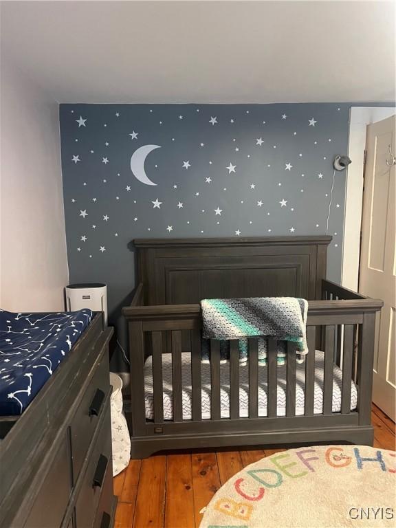 6265 Haslauer Rd, Stockbridge, NY 13409 - bedroom featuring wallpapered walls and hardwood / wood-style flooring
