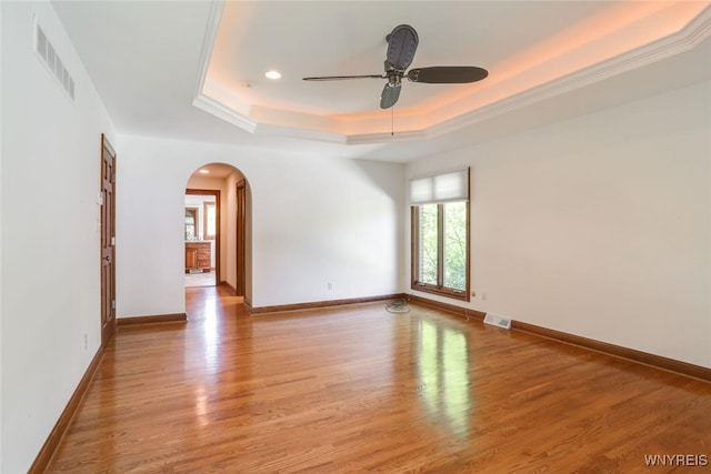 126 Crestwood Ln, Amherst, NY 14221 - spare room featuring arched walkways, a raised ceiling, ceiling fan, light wood-style floors, and baseboards