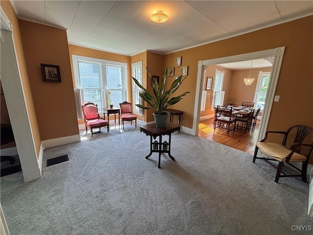 109 State St, Seneca Falls, NY 13148 - living area with carpet, ornamental molding, a chandelier, and baseboards