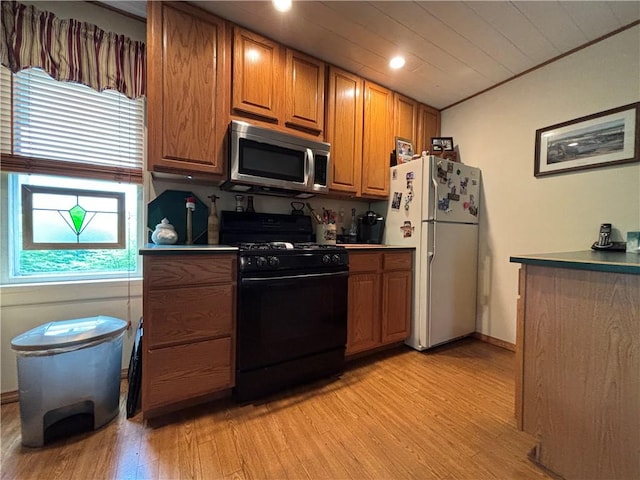 21 Curtis Rd, Hamilton, PA 16333 - kitchen featuring stainless steel microwave, black gas stove, freestanding refrigerator, brown cabinetry, and light wood-type flooring
