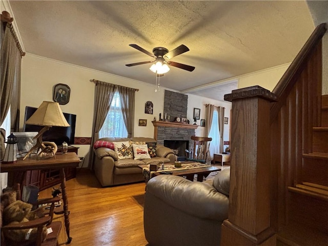 21 Curtis Rd, Hamilton, PA 16333 - living room featuring ceiling fan, light wood-style flooring, crown molding, a stone fireplace, and a textured ceiling