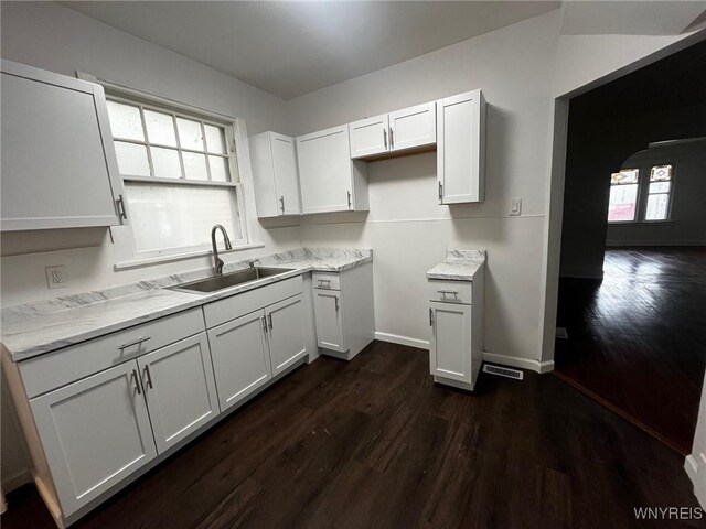 228 Weiss St, Buffalo, NY 14206 - kitchen featuring a sink, dark wood finished floors, baseboards, white cabinetry, and light stone countertops