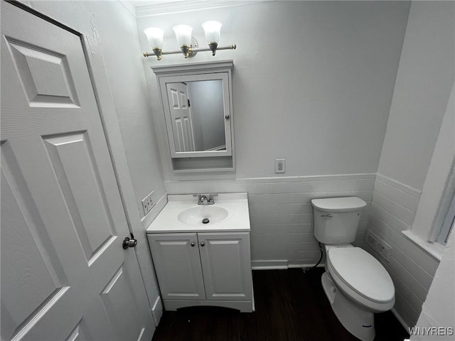 228 Weiss St, Buffalo, NY 14206 - half bathroom featuring vanity, toilet, wood finished floors, a wainscoted wall, and tile walls