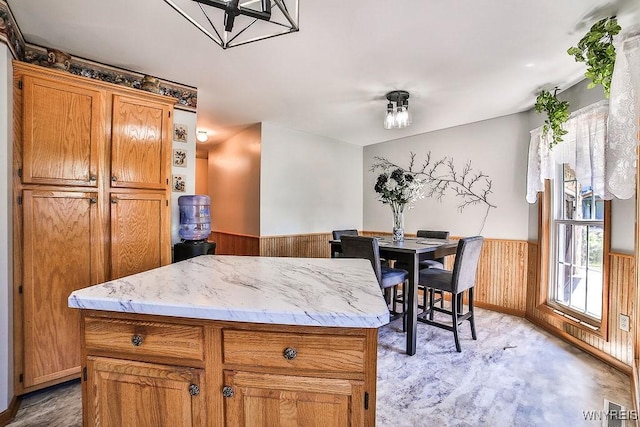 4590 Beach Ridge Rd, Pendleton, NY 14094 - kitchen with a wainscoted wall, brown cabinetry, a kitchen island, and wooden walls