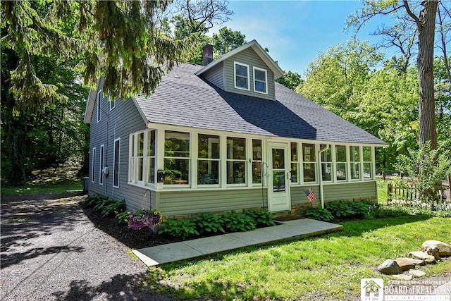 8 Terrace St, Westfield, NY 14787 - view of front of house featuring a shingled roof, a chimney, a sunroom, and a front lawn