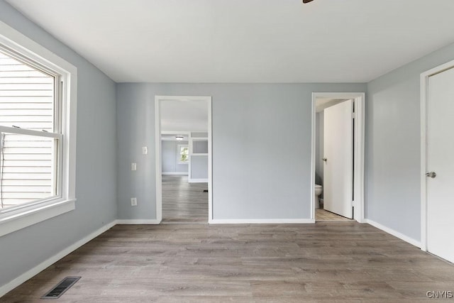 210 Essex St, Syracuse, NY 13204 - unfurnished bedroom with baseboards, wood finished floors, and ensuite bath